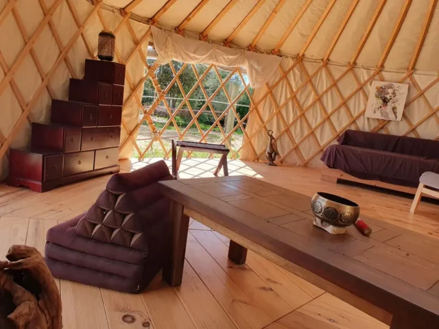Aménagement intérieur de la yourte avec vue sur l'enclos